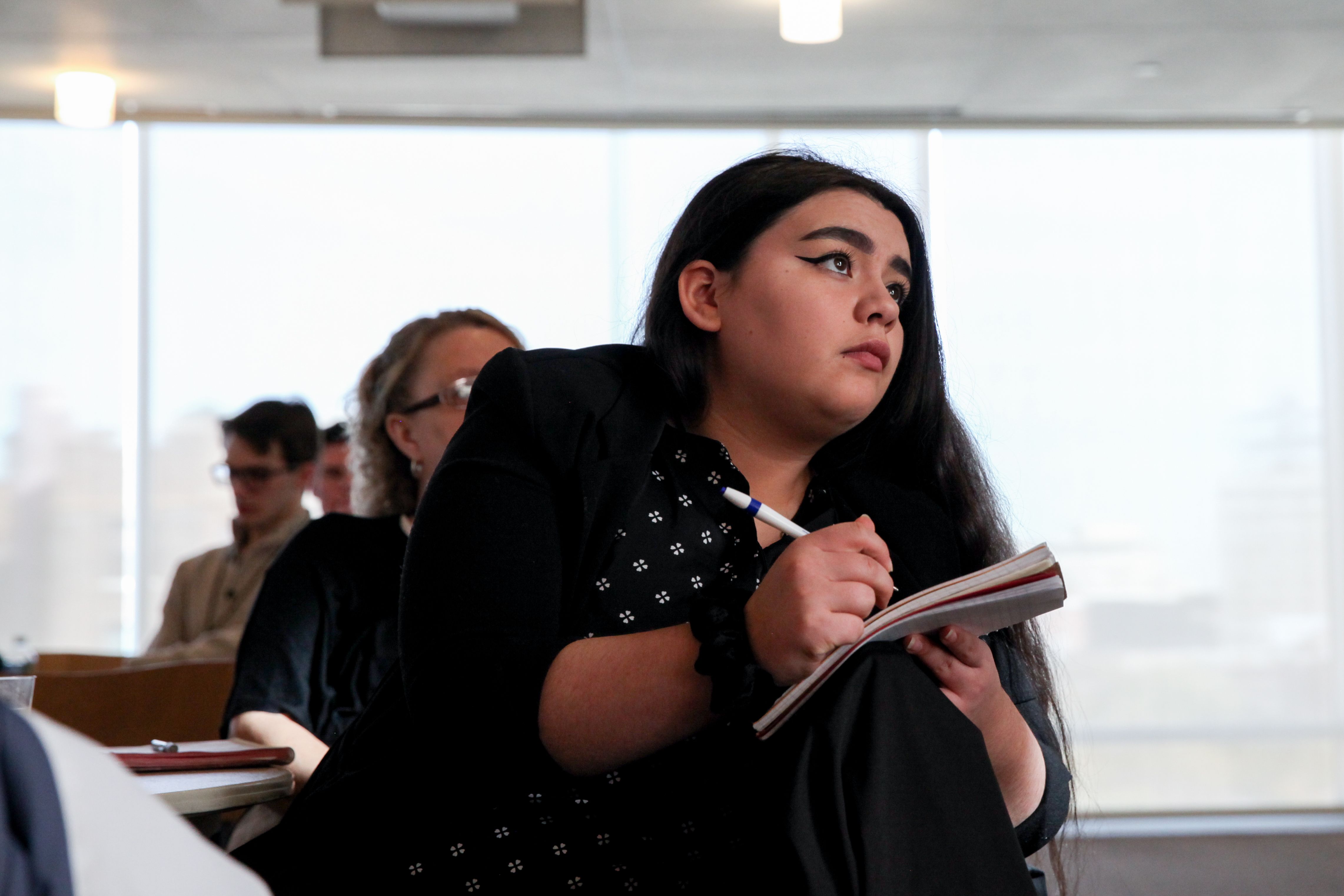 NSLS Member watching a presentation and taking notes.